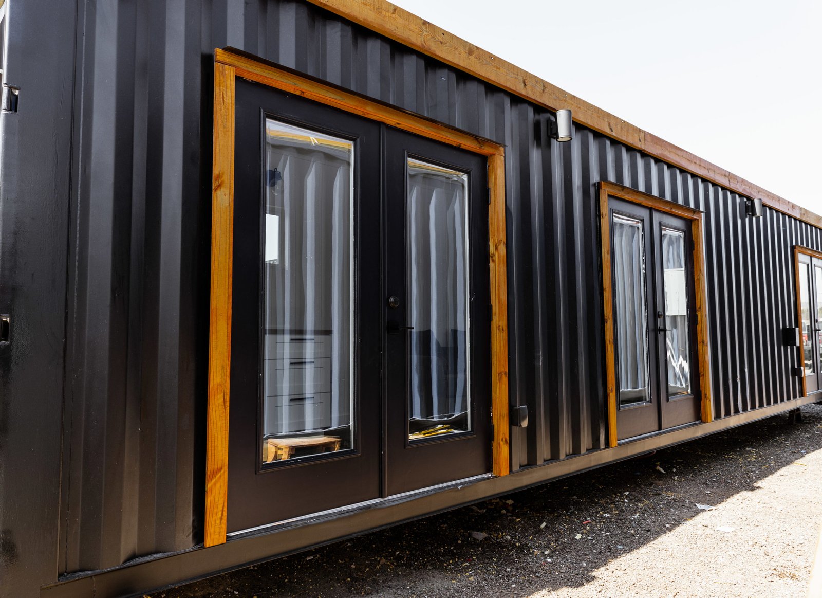 Black container home with cedar-framed glazed doors