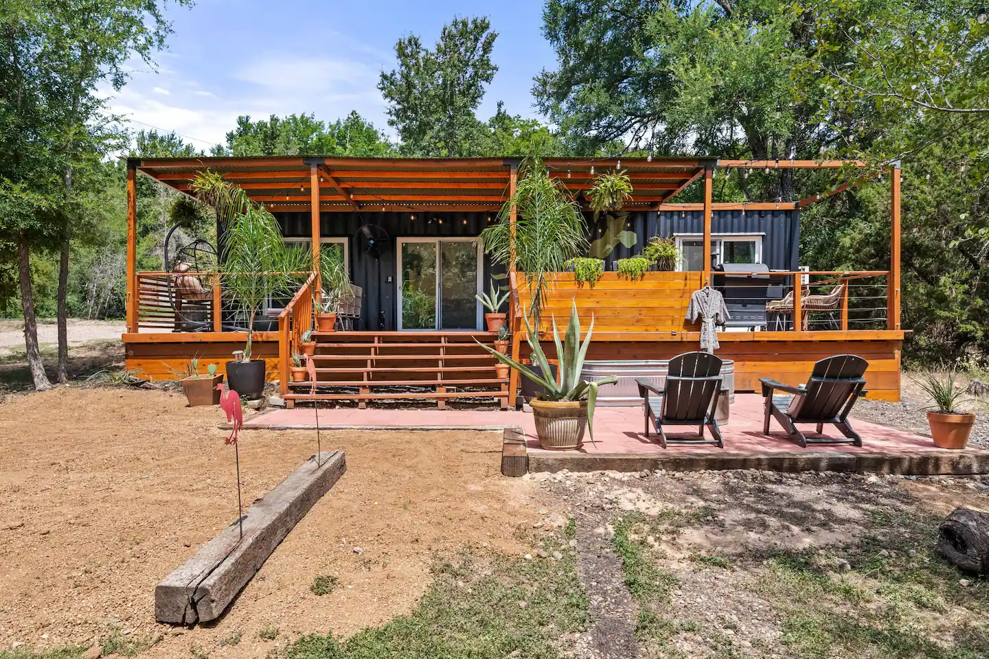 Black container cabin with cedar deck and hot tub