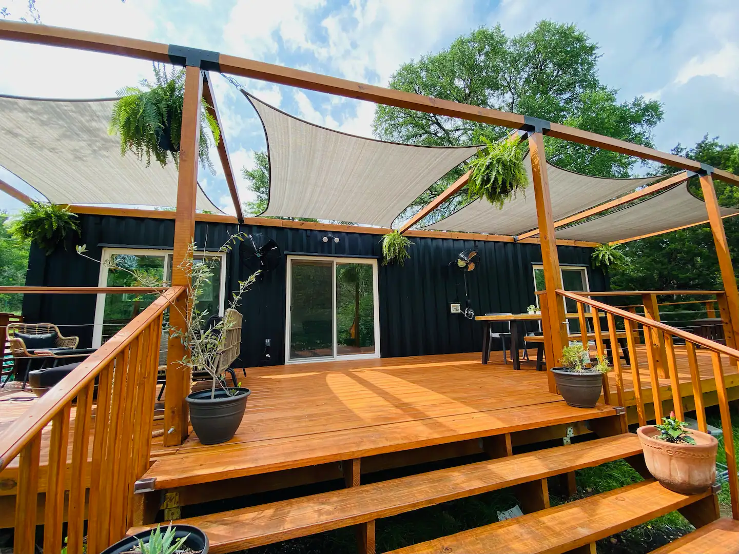 Container home deck shaded by fabric sails